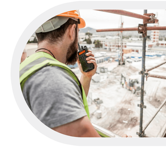 Construction worker communicating via a Motorola two-way radio on-site.